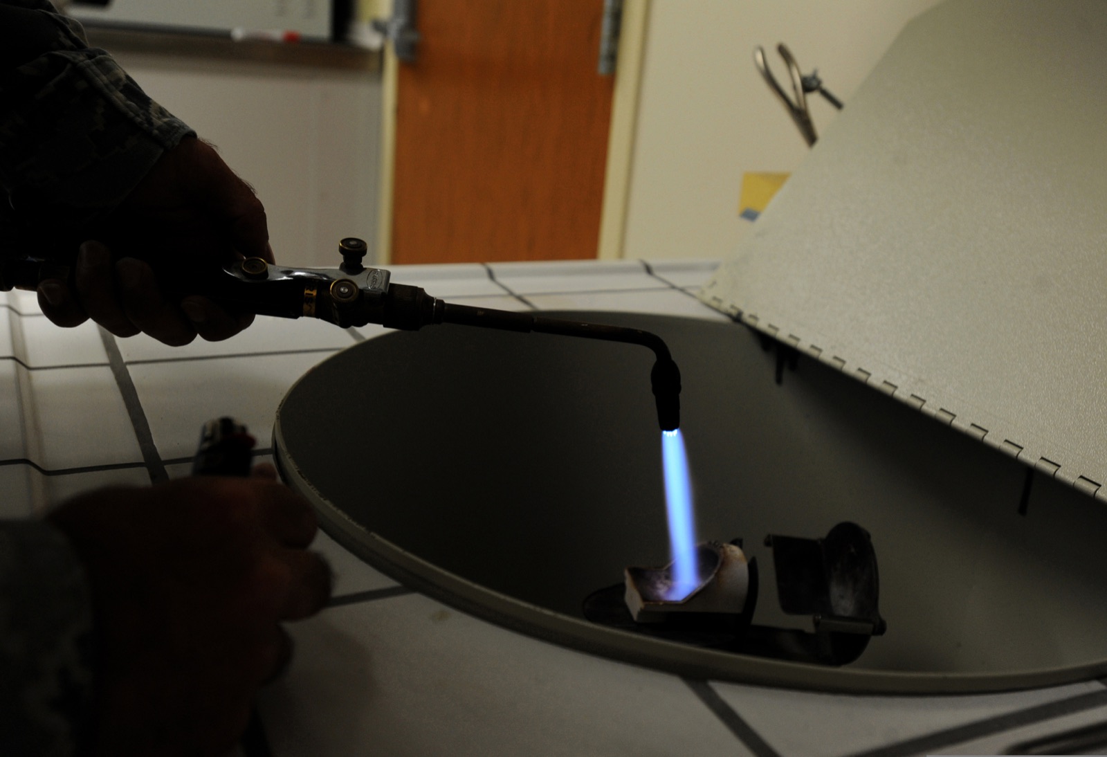 Foto: technicus van een tandtechnisch laboratorium smelt goud met de brander